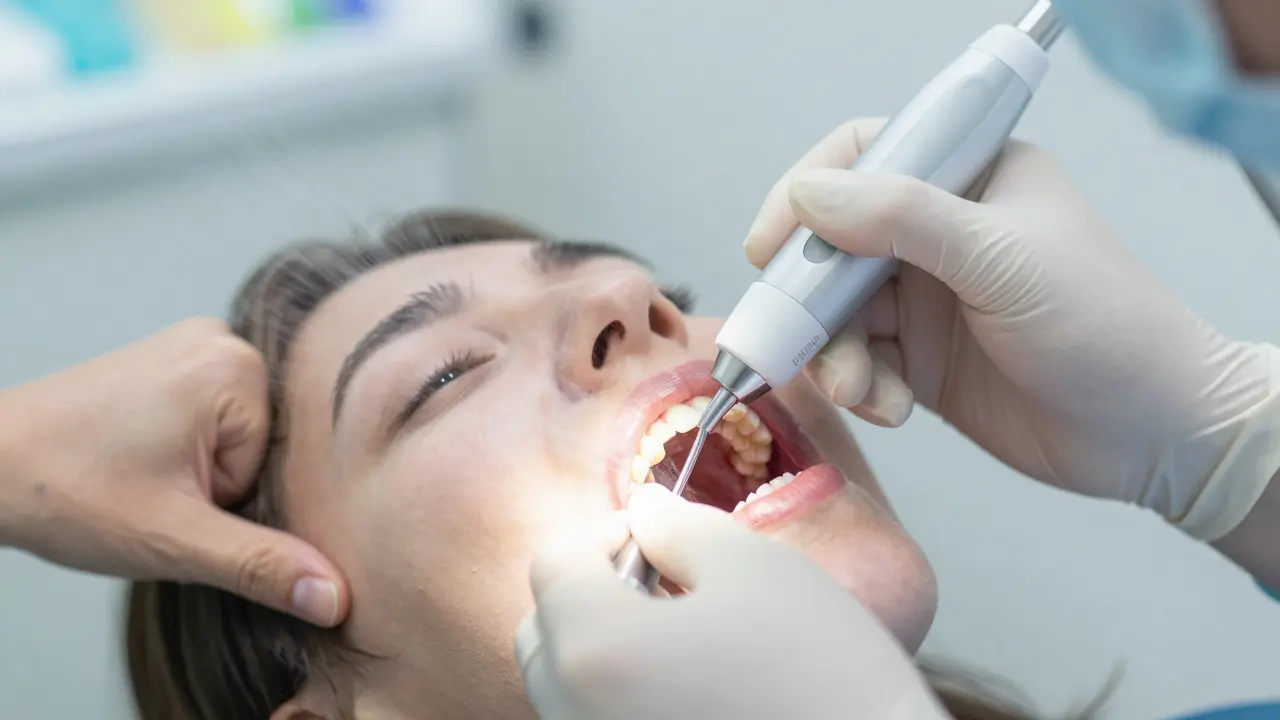 Hygienistka odstraňuje zubní kámen ultrazvukovým přístrojem.